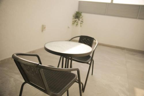 two chairs and a table and a table and chairs at נווה מדבר - צימרים ירוחם in Yeroẖam