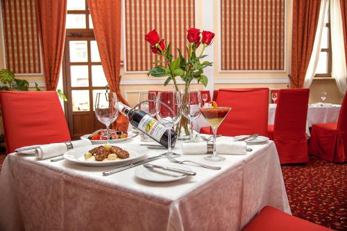 a table with a bottle of wine and a plate of food at Optima Collection Kamianets-Podilskyi in Kamianets-Podilskyi