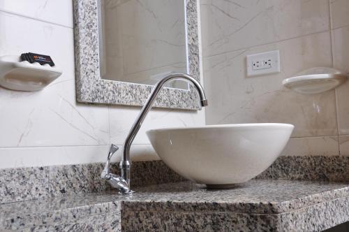 a bathroom with a white bowl sink on a counter at Hoteles Bogotá Inn La Soledad in Bogotá