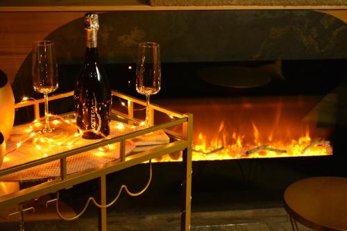 a table with wine glasses and a fireplace at A Casita del Pedro in Rimbachzell