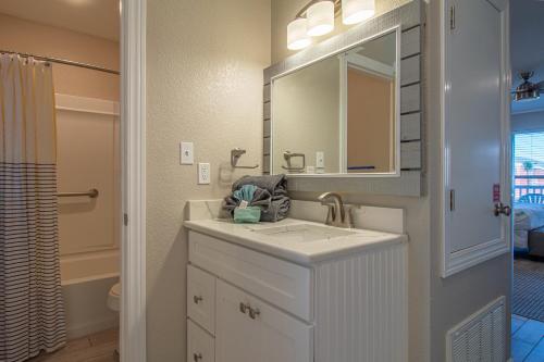 a white bathroom with a sink and a mirror at Executive Keys Condominiums on the Beach in Port Aransas