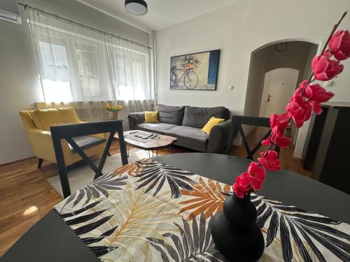 a living room with a table and a couch at Ira's Square 2 Bedroom Apartment Free Parking in Skopje