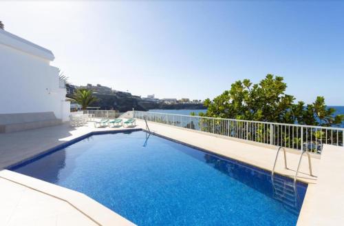 una piscina en un balcón con vistas al agua en Atardecer 1, en Puerto de Santiago