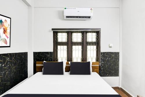 a bedroom with a large white bed with two pillows at Hotel O Azhar lodge in Calicut