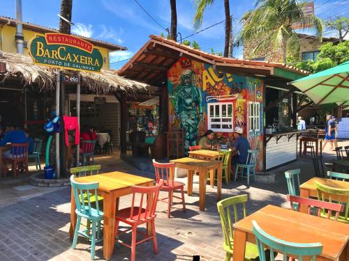 Un restaurante con mesas y sillas delante. en Flat Terreo n1 Porto de Galinhas c Piscina, en Porto de Galinhas