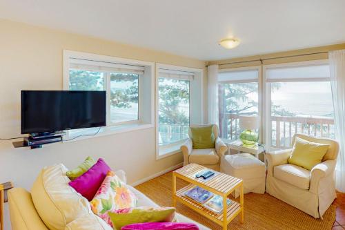 a living room with two couches and a flat screen tv at La Petite Maison in Oceanside