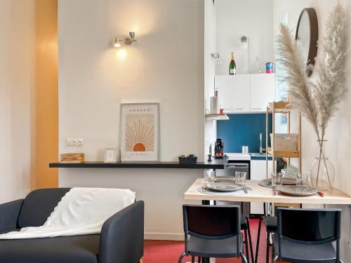 un salon avec un canapé et une table avec des chaises dans l'établissement L'Atypique - Place du Parlement - Coeur de Rennes, à Rennes