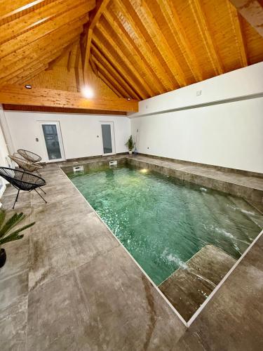 a swimming pool in a room with a wooden ceiling at L ecrin de Rosheim, villa d exception, piscine in Rosheim