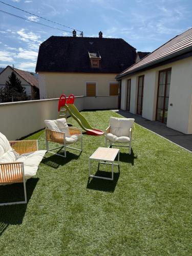 a yard with chairs and a playground with a slide at L ecrin de Rosheim, villa d exception, piscine in Rosheim