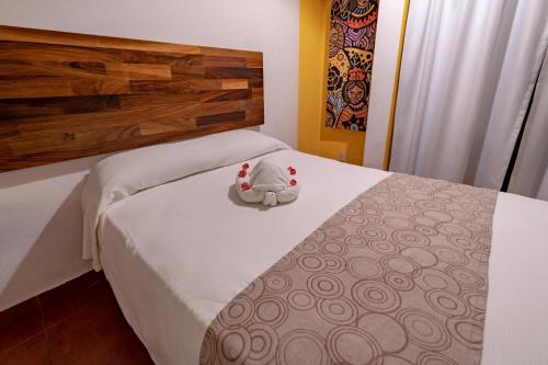 a stuffed animal is sitting on a bed at Hotel Santa Cruz Huatulco in Santa Cruz Huatulco