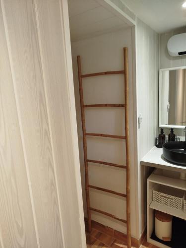 a stairway in a room with a sink and a mirror at Charmant Appartement en Provence in Caromb