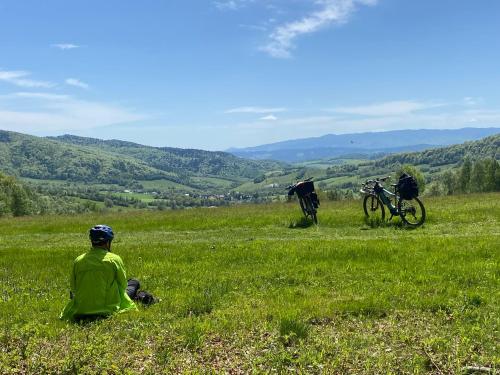 two people sitting in a field of grass with bikes at Józefówka - dom z 4 sypialniami, z balią ,dużym tarasem i pięknym widokiem na Wysową in Wysowa-Zdrój