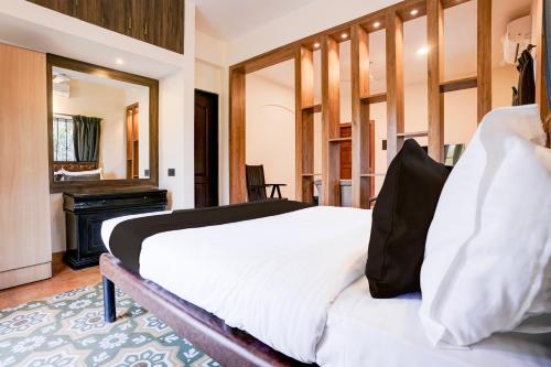 1 dormitorio con cama y piano en Collection O Dona Karen, en Goa