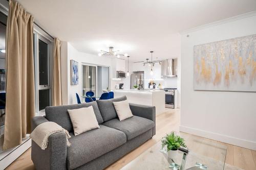 a living room with a couch and a kitchen at Gorgeous Downtown Unit with City Views in Vancouver