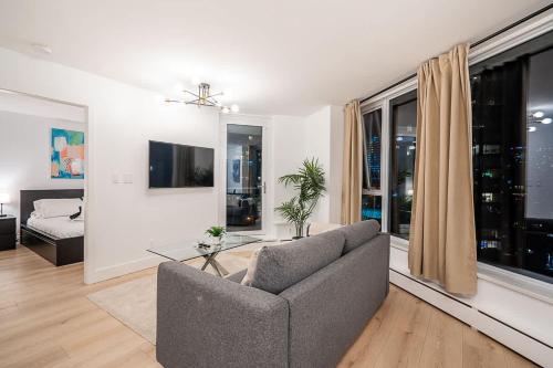 a living room with a couch and a window at Gorgeous Downtown Unit with City Views in Vancouver