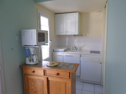 - une cuisine avec une cafetière au-dessus d'un comptoir dans l'établissement Charmante maison F3 proximité plage, à Saint-Hilaire-de-Riez
