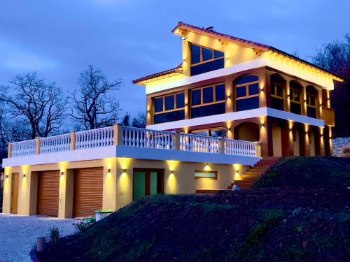 a large house with lights on it at night at Villa Beelvita&Jacuzzi in Bielovce