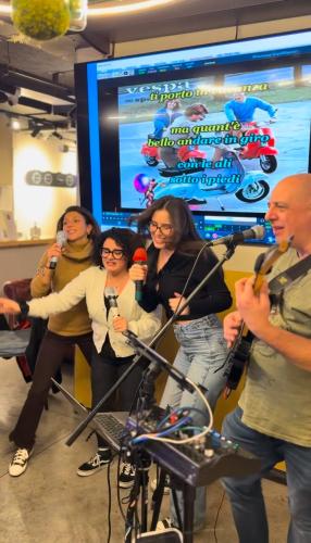 a group of people standing in a room with microphones at Marathon Hostel in Genova