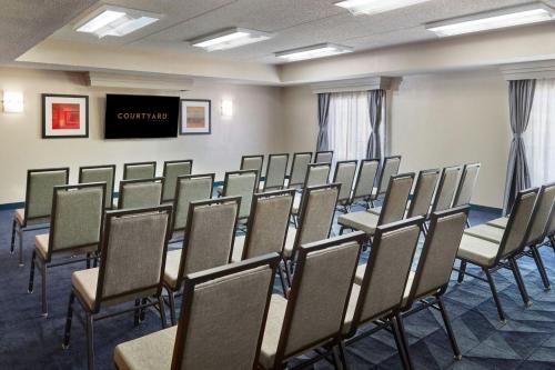 a conference room with chairs and a flat screen tv at Courtyard by Marriott Baton Rouge Acadian Centre/LSU Area in Baton Rouge