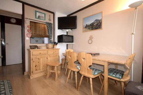 une cuisine et une salle à manger avec une table et des chaises en bois dans l'établissement Résidence Mont Blanc - Appartement 3 pièces 6 personnes - Plagne Centre MAE-5084, à La Plagne Tarentaise