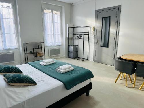 une chambre avec un grand lit avec des serviettes dessus dans l'établissement Studio 1 Proche Centre Ville Wifi et Parking Troyes, à Troyes