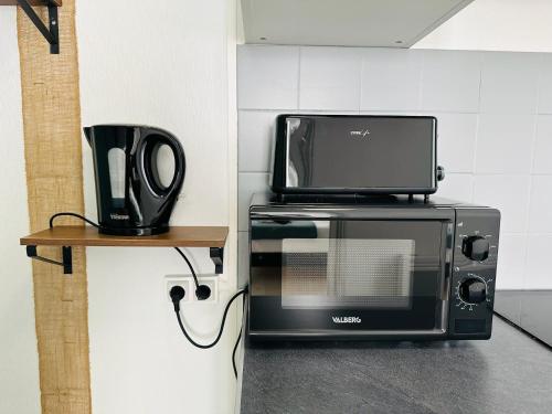 Un four micro-ondes est installé au-dessus d'un grille-pain. dans l'établissement Studio 1 Proche Centre Ville Wifi et Parking Troyes, à Troyes