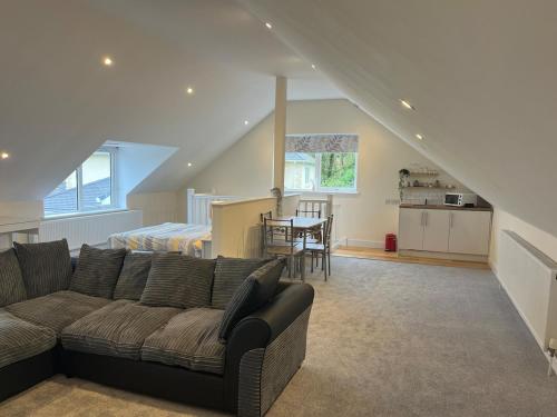 a living room with a couch and a kitchen at Studio Apartment with games room in Royal Wootton Bassett