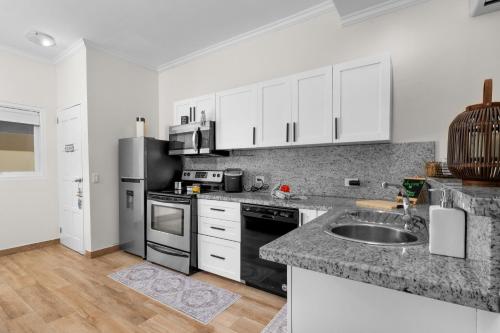 a kitchen with white cabinets and a sink at Aruba Breeze C4 in Palm-Eagle Beach