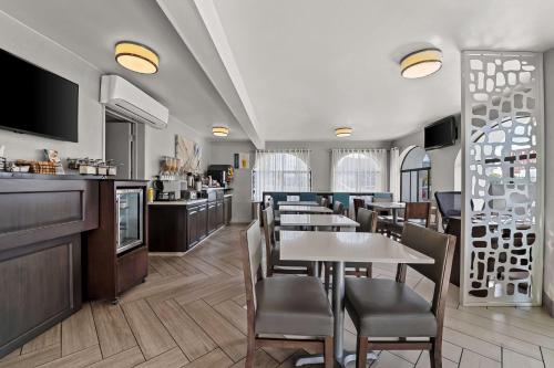 Un restaurante con mesas y sillas y un bar. en Best Western Los Alamitos Inn & Suites, en Los Alamitos