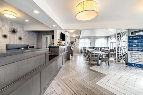 a restaurant with a bar and tables and chairs at Best Western Los Alamitos Inn & Suites in Los Alamitos