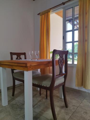 una mesa de madera con 2 sillas y copas de vino en Refugio del viajero, en Chajarí