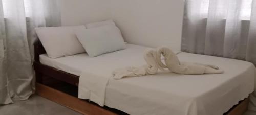 ブトゥアンにあるRhexus Homestayの白いシーツが敷かれたベッドが2つある寝室