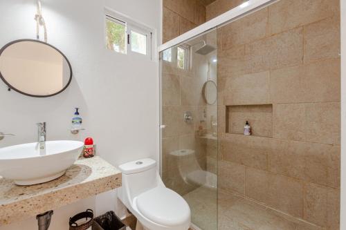 a bathroom with a toilet and a sink and a shower at Casa Acalan in Puerto Morelos