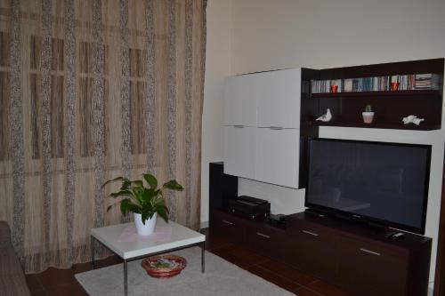 een woonkamer met een flatscreen-tv bij The Bamboo House in Santa Venerina