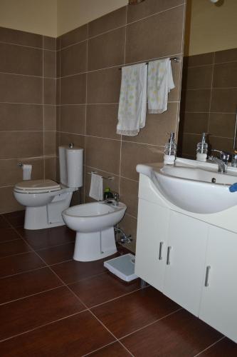 a bathroom with two toilets and a sink at The Bamboo House in Santa Venerina