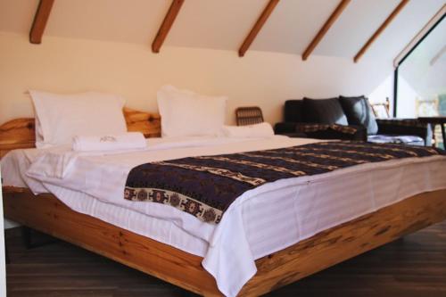 a bedroom with a large bed with white sheets at Montis Resort in Yeghegis