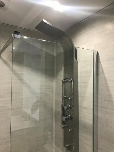 une douche avec une porte vitrée dans une salle de bain dans l'établissement Charming Gite in the Normandy countryside, à Saint-Mars-dʼÉgrenne