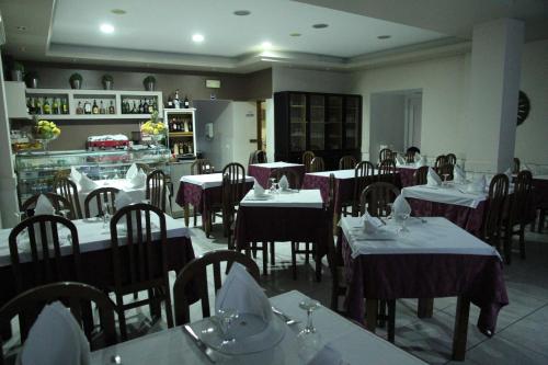 un restaurant avec des tables et des chaises et des nappes pourpres dans l'établissement Hotel Katia, à Chaves