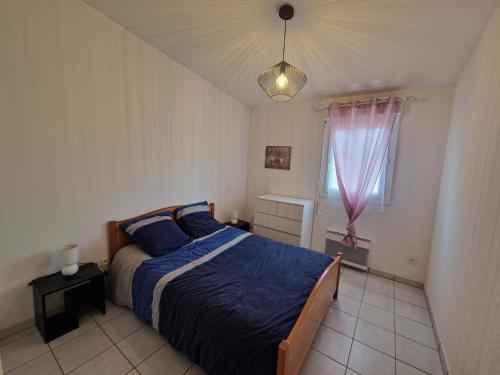 une chambre avec un lit avec des draps bleus et une fenêtre dans l'établissement SUPERBE T2 RESIDENCE LE RAPIN 4 personnes, à Port-la-Nouvelle