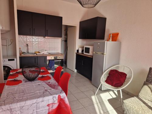 une cuisine avec une table, des chaises et un réfrigérateur dans l'établissement SUPERBE T2 RESIDENCE LE RAPIN 4 personnes, à Port-la-Nouvelle