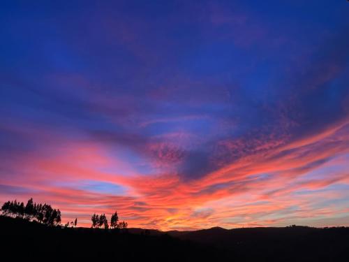 a sunset with colorful clouds in the sky at Vale das Estrelas in São Teotónio