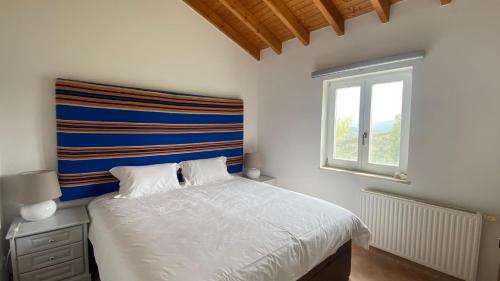 a bedroom with a bed and a window at Vale das Estrelas in São Teotónio