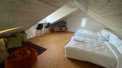 a bedroom with a white bed and a attic at Vale das Estrelas in São Teotónio