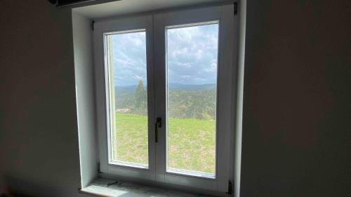 an open window with a view of a green field at Vale das Estrelas in São Teotónio
