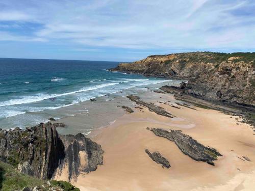 an aerial view of a beach with rocks and the ocean at Vale das Estrelas in São Teotónio