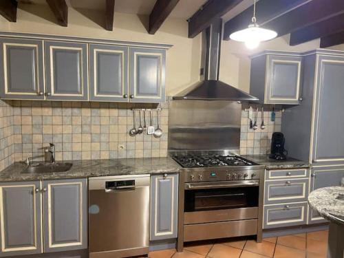 ポール・サン・ルイ・デュ・ローヌにあるLe Meublé de marineのキッチン(ステンレス製の電化製品、白いキャビネット付)