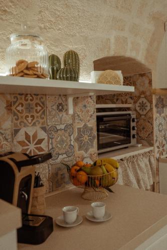 a kitchen with a table with a bowl of fruit on a counter at Casa Vacanza Il Piccolo Principe in Ginosa