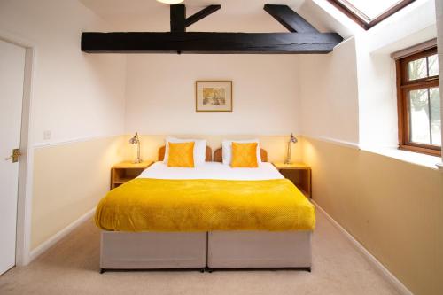 a bedroom with a bed and two windows at Newton House Hotel in Alstonfield