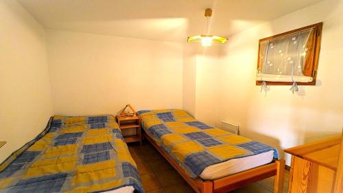 una habitación con dos camas y una ventana en Résidence Les Queyrettes - Grand appartement confortable 4/6 personnes MAE-6851, en Puy-Saint-Vincent