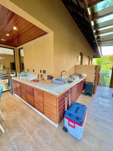 an outdoor kitchen with a sink and a counter at Bangalô com 3 suítes no Eco Resort na Praia dos Carneiros in Tamandaré